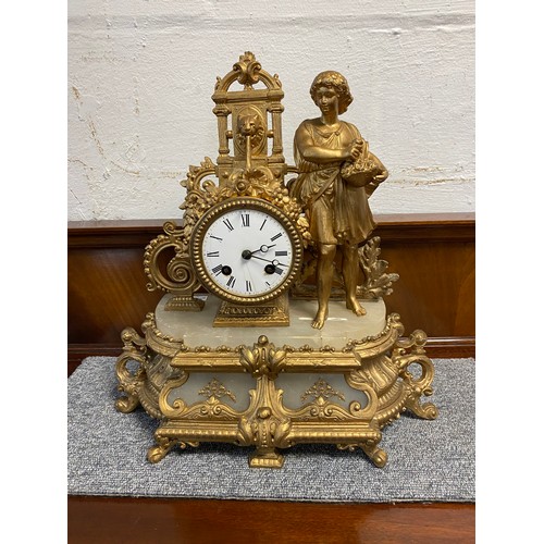 325 - A gilt metal figural mantel clock, depicting a figure with a basket beside a fountain -