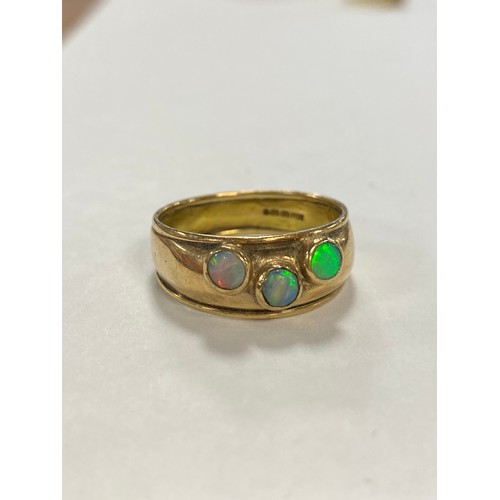 53 - A 9ct gold band ring, set with three opal cabochons -