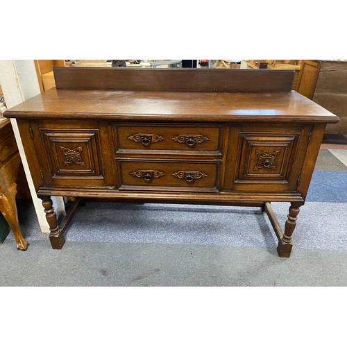 351 - An oak sideboard, fitted with two drawers flanked by cupboard doors on turned supports -