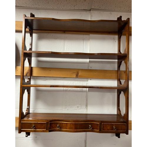 321 - A mahogany wall shelf, with pierced sides and shaped shelves, fitted with three drawers -