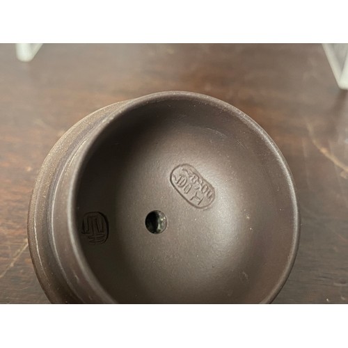 130 - A Chinese Yixing teapot, the cover with inset knop, the lobed body with impressed seal mark -