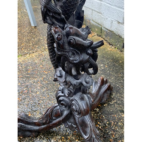 383 - A Chinese carved hardwood table, with later top, the column elaborately carved as a climbing dragon,... 