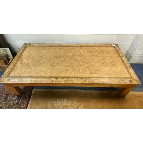 386 - A large Chinese style opium table, the low table with canework top on short legs -