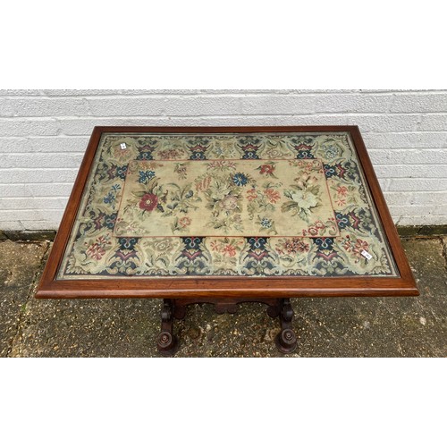 413 - A Victorian rosewood games table, with needlework replacement top over two drawers and scrolled end ... 