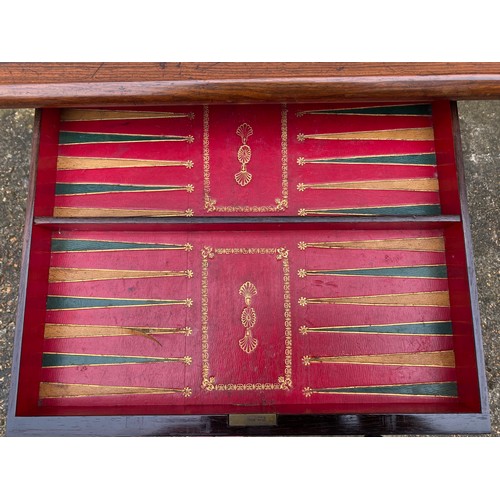 413 - A Victorian rosewood games table, with needlework replacement top over two drawers and scrolled end ... 