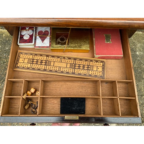 413 - A Victorian rosewood games table, with needlework replacement top over two drawers and scrolled end ... 