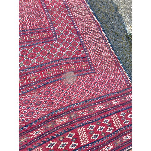 425 - A red ground rug, approximately 165 x 280cm -