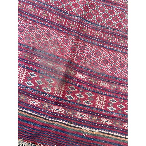 425 - A red ground rug, approximately 165 x 280cm -