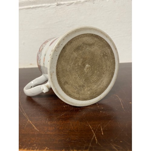111 - A Chinese export mug, enamelled with floral decoration, the handle mounted with trefoils -