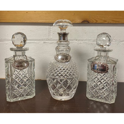 63 - A cut glass decanter and stopper, with silver 'Port' decanter label, another 'brandy' and another wi... 