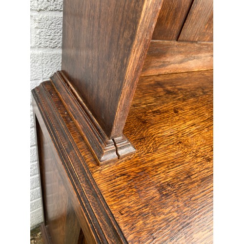 245 - An early 20th century oak dresser, the shelved top  over two drawers and cupboard doors, on ball and... 