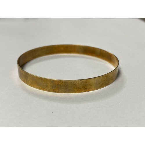 7 - A yellow metal bangle, stamped 375 -