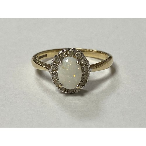 10 - A 9ct gold dress ring, set with an oval opal and diamond cluster -