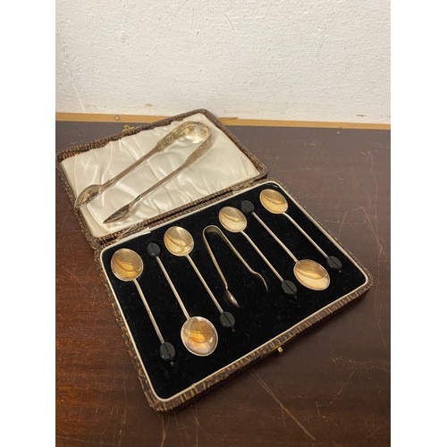 20 - A cased set of six bean end coffee spoons, with tongs and another pair of tongs -