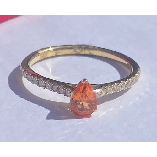 53 - An 18ct gold dress ring, set with a pear cut orange  stone within diamond set shoulders -