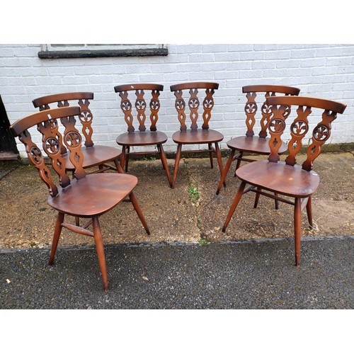 215 - A Ercol drawer leaf dining table and a set of six Ercol Prince of Wales/Fleur de lys back chairs -