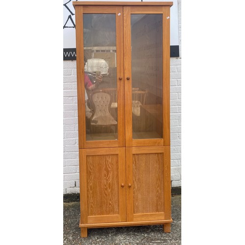 218 - An oak display cabinet, with two glazed doors over cupboard doors -