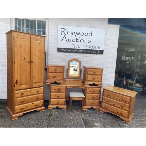 220 - A modern pine bedroom suite, comprising dressing table with mirror, wardrobe, chest of drawers and p... 