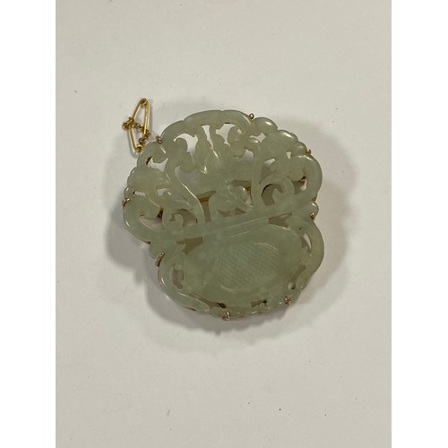 43 - A Chinese carved jade brooch, carved in an openwork floral design, in yellow metal mount -