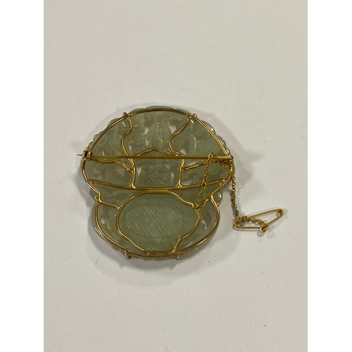 43 - A Chinese carved jade brooch, carved in an openwork floral design, in yellow metal mount -