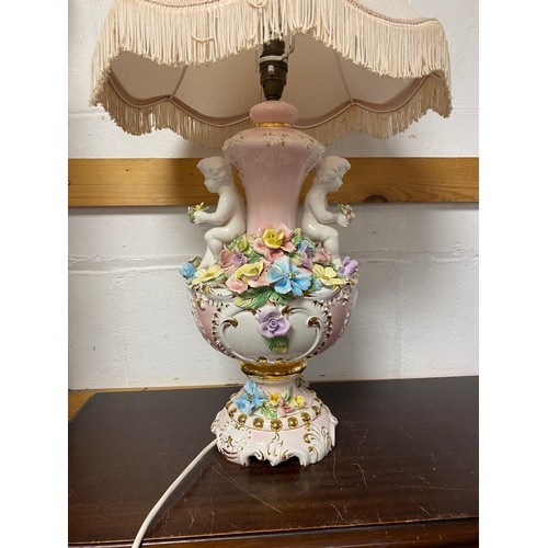 304 - An Italian table lamp, modelled as an urn with two cherubs and encrusted with flowers -