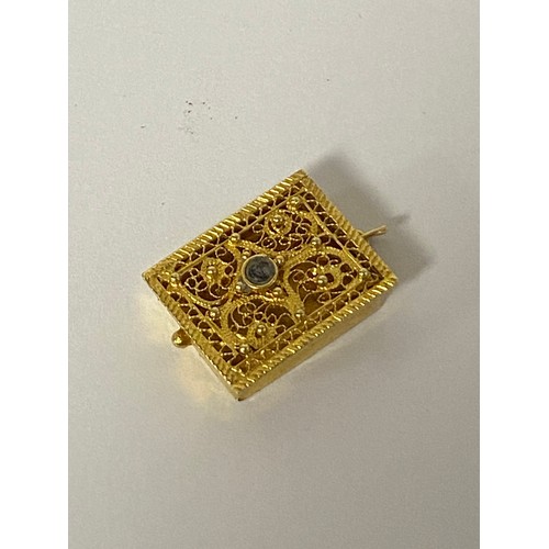 34 - A yellow metal locket, rectangular and with filigree cover -