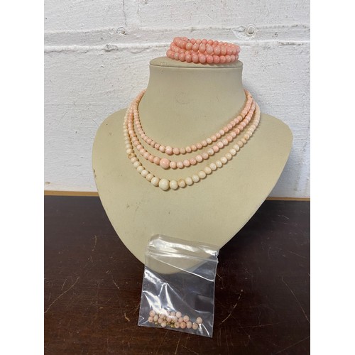 35 - A three row pink coral bead necklace, a pink coral bracelet and loose beads -