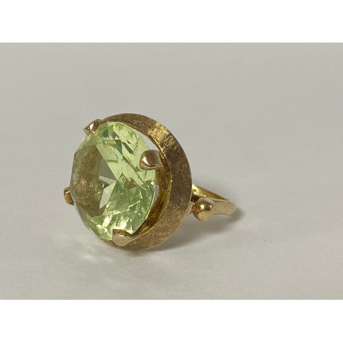 41 - A gem set dress ring, the large circular green stone in a yellow metal mount, stamped 18k -