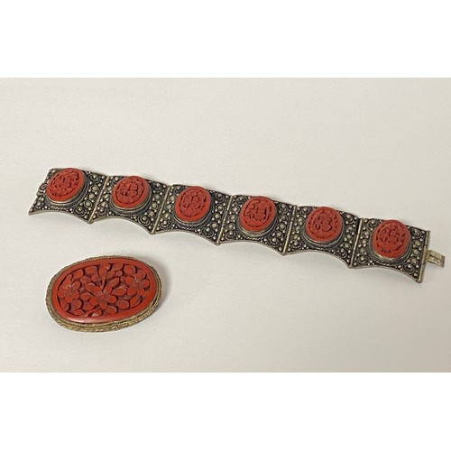 43 - A Chinese lacquered panel bracelet, composed of flexible white metal panels inset with oval cinnabar... 