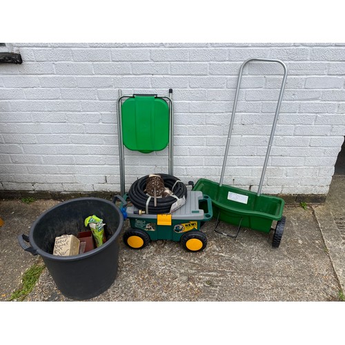 393 - A garden spreader, together with a garden trolley, a waste bag holder etc -