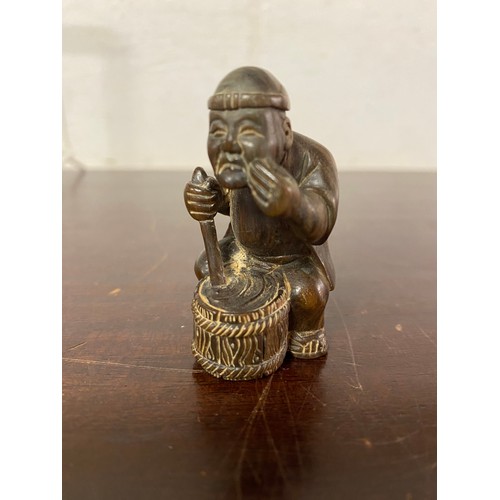 100 - A Japanese carved netsuke, depicting a seated fisherman -