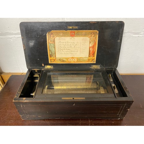 103 - A 19th century Swiss music box, the rosewood case with garland inlay, playing 6 airs -