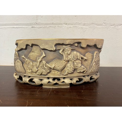 145 - An oval planter, in the Chinese taste, moulded with figures -