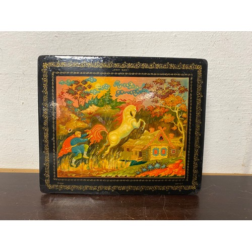 107 - A Russian lacquered box, the cover decorated with a leaping horse -