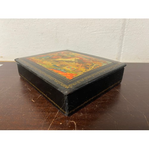 107 - A Russian lacquered box, the cover decorated with a leaping horse -