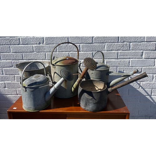 413 - Three galvanised watering cans, together with a bucket and a pan (5) -