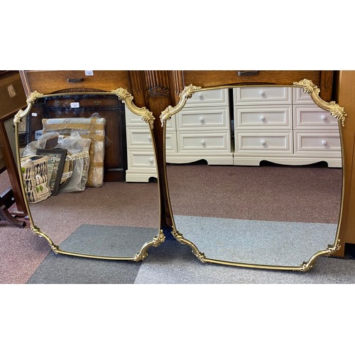 365 - A pair of gilt framed wall mirrors, each with shaped plate and scrolled canted corners -