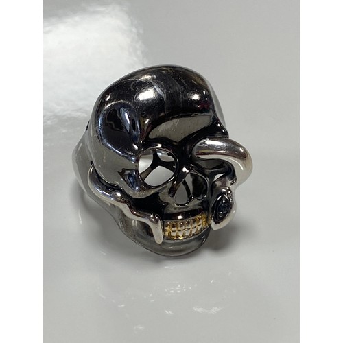 35 - A continental 18ct gold ring, designed as a skull with a diamond set snake, in tri-colour gold, stam... 