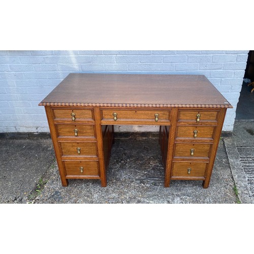 366 - An oak desk, fitted with three frieze drawers over drawers on short legs -