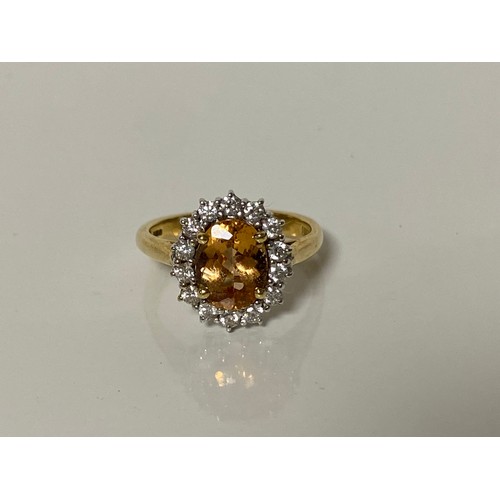 40 - An 18ct diamond and gem set dress ring, set with an oval orange stone, within a border of diamonds, ... 