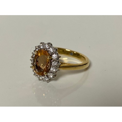 40 - An 18ct diamond and gem set dress ring, set with an oval orange stone, within a border of diamonds, ... 