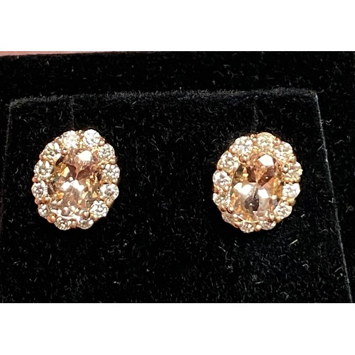 41 - A pair of gem set diamond earrings, set with an oval pink stone in a border of diamonds, set in 14k ... 