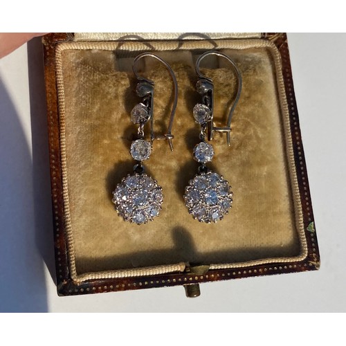 44 - A pair of antique diamond ear pendants, each set with three graduated old cut diamonds above a clust... 