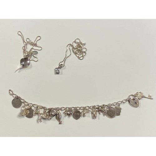 45 - A silver charm bracelet, together with two silver pendants on chains -