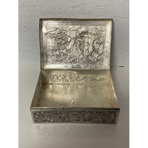 90 - A Chinese white metal box, the cover repousse decorated with figures and landscape -