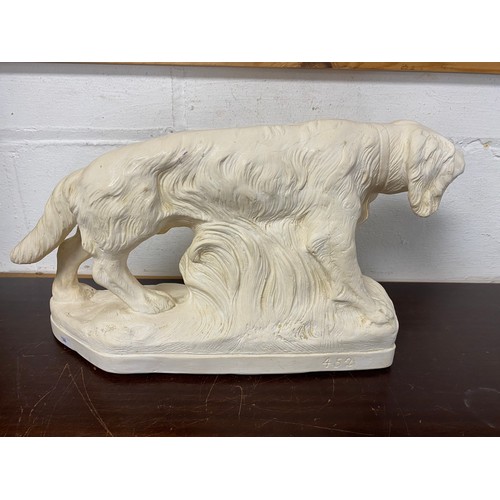 106 - A 20th century sculpture of a hunting dog, signed -