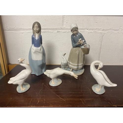 120 - A Lladro figure of a girl feeding geese, three Lladro geese and a Nao figure of a girl -