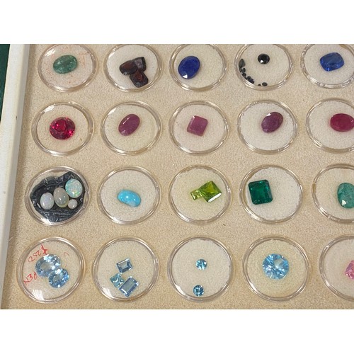 53 - A large tray of precious and semi-precious loose gemstones, including aquamarine, emeralds, rubies, ... 