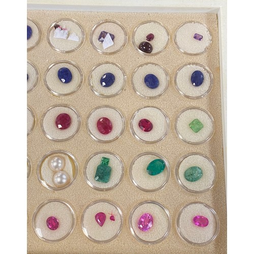 53 - A large tray of precious and semi-precious loose gemstones, including aquamarine, emeralds, rubies, ... 