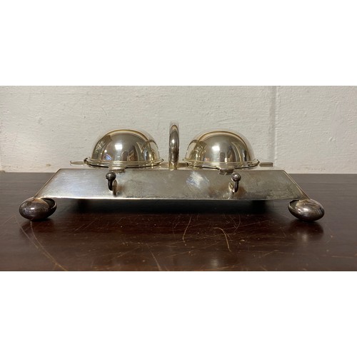 57 - An Edwardian silver plated desk stand, fitted with two cut glass inkwells with rollover covers -